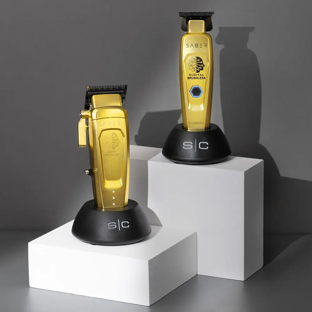 Two gold hair trimmers on white and gray stands against a dark background