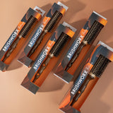 Multiple BRUSHWORX hairbrushes in packaging on a beige background