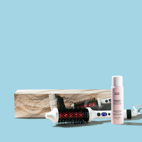 Hair styling tools including a brush, bottle, and box on a light blue background